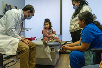 Photo of Dr.Sam Wainwright talking with a patient and her mother.