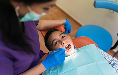 Dentist examining young patient in clinic